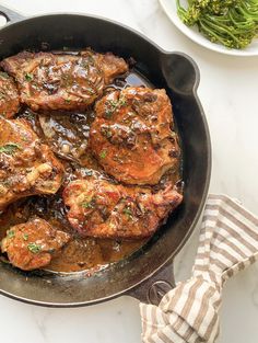 some meat is cooking in a pan on the table