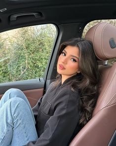 a woman sitting in the back seat of a car