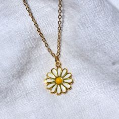 This necklace features an enamel 14x17mm daisy charm attached to a 16" chain. All materials are 24k gold plated, tarnish resistant, lead, and nickel free. Matching earrings available here. Full necklace and earrings set available here. 70s Jewelry Necklaces, Enamel Necklaces With Flower Charm And Pendant, Enamel Flower Pendant Necklace With Charm, Enamel Flower Pendant Necklace With Flower Charm, Trendy Gold Flower-shaped Jewelry, Trendy Yellow Gold Enamel Jewelry, White Adjustable Charm Necklace With Flower Charm, Enamel Pendant Jewelry With Flower Charm, Cute White Nickel Free Necklaces