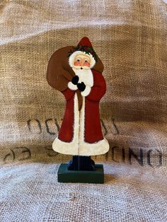 a santa clause figurine is standing on top of a burlap sack