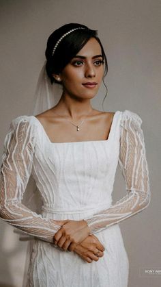 a woman in a white wedding dress and veil