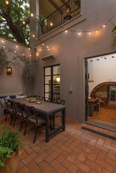 an outdoor dining area with patio furniture and string lights