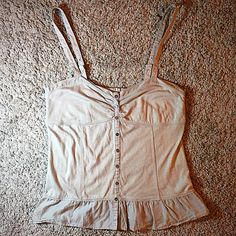 American Eagle Outfitters Size Small Button Up Tank Top In Gray. Nwots, Never Worn Just Kept In Closet Storage. Has Cute Button Up And Bust Detail And Ruffle Hem At Bottom. Straps Are Adjustable By A Tiny Button On Each Side. Back Had A Stretch Panel For Good / Adjustable Fit At Bustline. In Perfect Condition Just A Little Wrinkled. So Cute! Casual Beige Tops With Snap Buttons, Summer Cotton Tops With Snap Buttons, Fitted Beige Tops With Buttons, Beige Tops With Button Closure For Everyday, Vintage Button Closure Tops For Day Out, Vintage Tops With Buttons For Day Out, Casual Vintage Tops With Buttons, Vintage Buttoned Top For Day Out, Cotton Tops With Buttons For Day Out