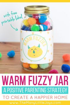 a jar filled with colorful pom - poms on top of a wooden table