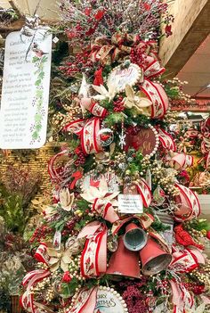 a christmas tree decorated with red and white ribbons