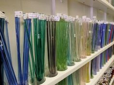 there are many different colored candles on the shelves in this store, all lined up and ready to be bought