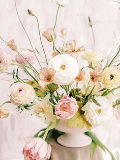 a vase filled with lots of white and pink flowers