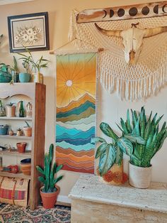 a room filled with potted plants and pictures on the wall