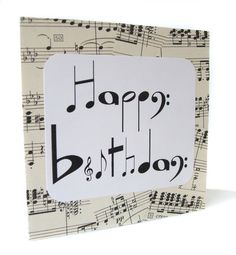 a birthday card with musical notes and the words happy birthday written in black on it