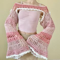 a mannequin wearing a pink and white top with crocheted lace sleeves