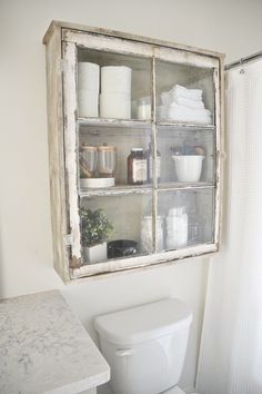 a white toilet sitting in a bathroom next to a window