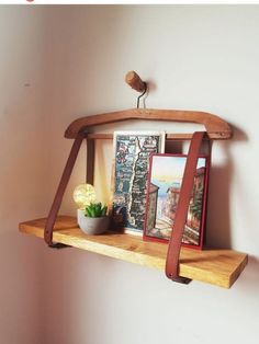 a wooden shelf with pictures and a potted plant on it