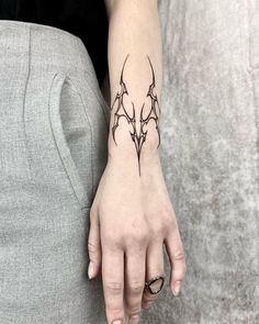 a woman's hand with a tattoo design on the left side of her arm