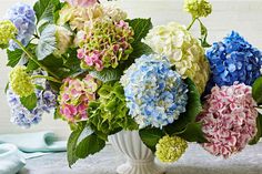 a vase filled with lots of colorful flowers on top of a table next to a blue towel