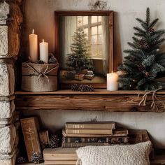 a mantle with books, candles and a christmas tree