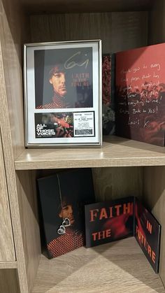 some books are sitting on a shelf with pictures and other items in the bookcase