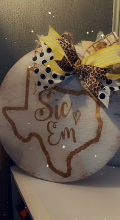 a wooden sign that says sicc'em with a cheetah and polka dot bow