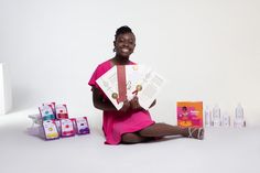 a woman sitting on the ground holding up a paper