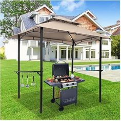 an outdoor bbq grill in the grass with a red cover over it and a pool behind it