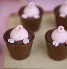 small cupcakes with pink frosting shaped like pigs