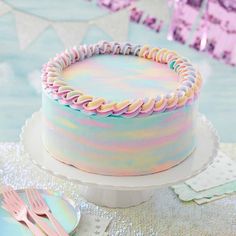 a cake with pastel icing on it sitting on top of a table next to a fork