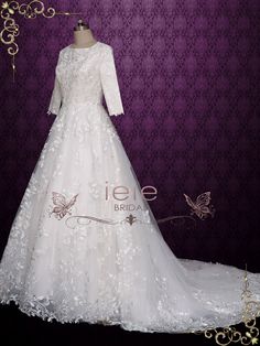 a white wedding dress on display in front of a purple background