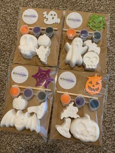 four boxes filled with halloween decorations on top of a carpeted floor next to each other