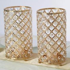 two gold colored vases sitting on top of a table