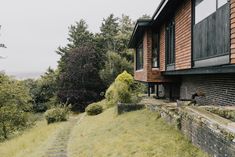 a house on the side of a hill with stairs leading up to it and trees in the background