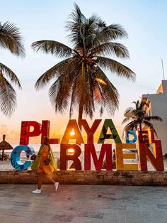 a woman walks past the playa del mar men sign in front of palm trees