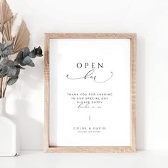 an open day sign next to a vase with flowers