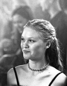 a black and white photo of a woman in a dress with pearls on her neck