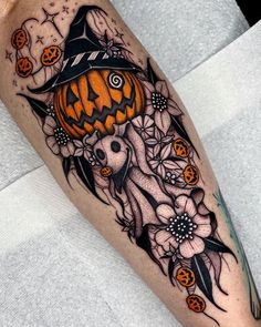 a person with a tattoo on their leg and some pumpkins in the sky above them