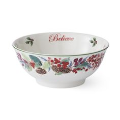 a white bowl with red berries and pine cones on the rim that says belevee