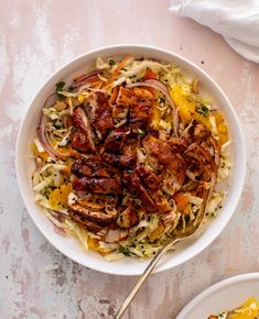 a white bowl filled with meat and vegetables