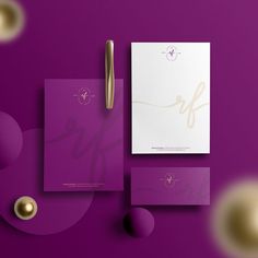 the stationery is purple and gold, with a pen next to it on a purple surface