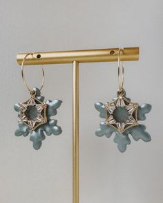 a pair of earrings is hanging from a stand