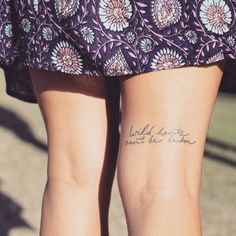 the back of a woman's legs with tattoos on them and words written in cursive writing