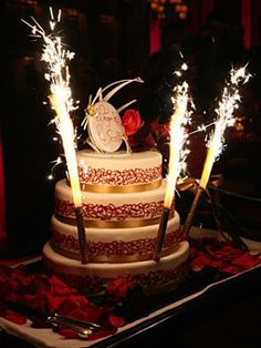 a three tiered cake with sparklers on top