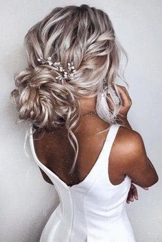 the back of a woman's head wearing a white dress and hair combs