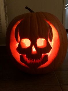 a pumpkin carved to look like a skull with glowing eyes