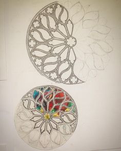 two circular stained glass pieces sitting on top of a white wall