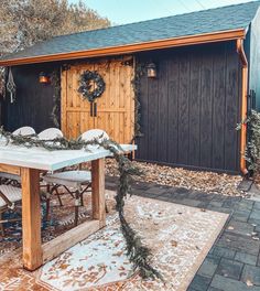 a table and chairs in front of a building with a christmas wreath on the table