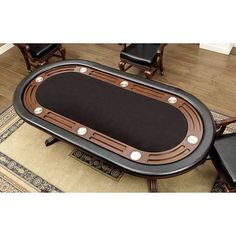 a black table sitting on top of a wooden floor next to chairs and rugs