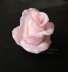 a pink rose sitting on top of a black table