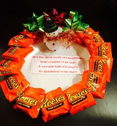 a wreath made out of candy bars with a snowman on top