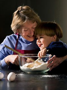 an older woman and young child mixing food together