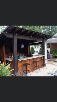 an outdoor bar with stools and barstools in the middle of a yard