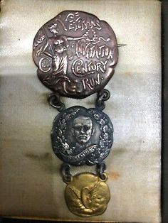 an old metal plaque with two medallions attached to it