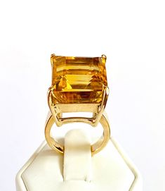 A stunning cocktail statement ring featuring a large square cut of 28.95 carats natural Citrine gemstone.  The Citrine is set 4 prongs set into an elegant basket head. The ring has been hand crafted in 11K yellow Gold with thick wide ring band.  The ring has been beautifully hand made to showcases this strikingly magnificent gemstone of deep golden colour.  It has been created with simple lines combine with big bold gemstone, a classic design with contemporary looks.   Only 1 is available.  Clar Gold Ring Engagement, Golden Colour, Citrine Pendant, Etsy Gold Ring, Red Gemstones, Wide Rings, Citrine Stone, Natural Citrine, Wide Band Rings